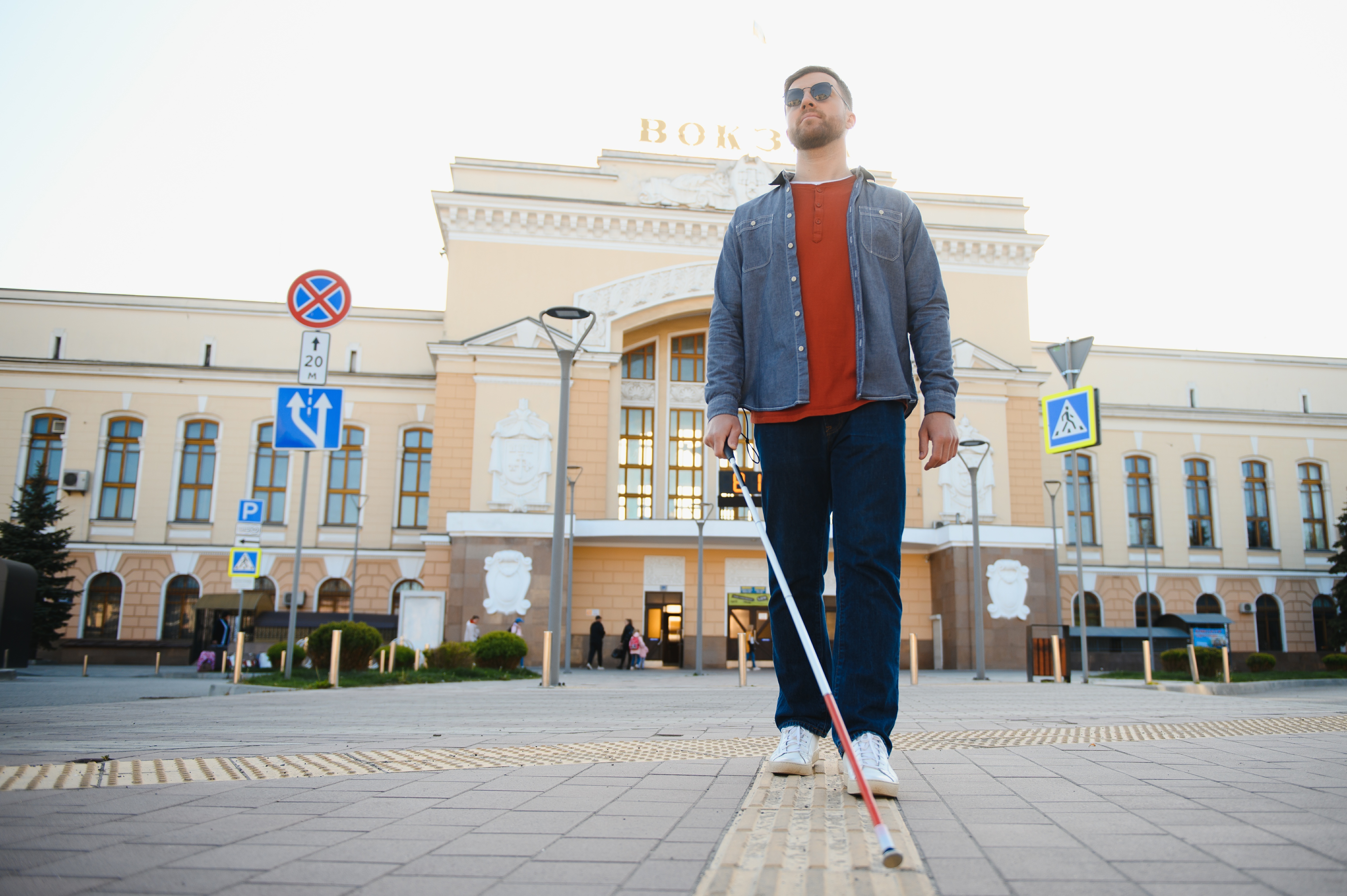 visually impaired man walking around the city